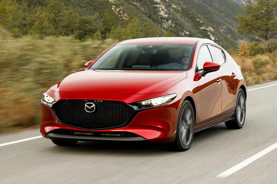 Image of a red 2019 Mazda3 driving fast down a highway.